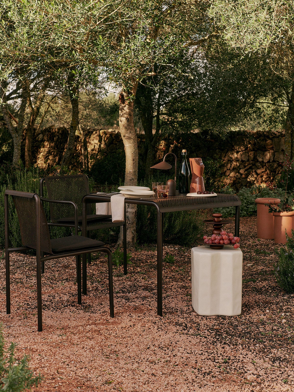 Dapple Stol, Dapple Karmstol och Dapple Bord 80x80 i färgen Dark Chocolate på uteplats i solnedgången