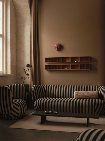 Kompliment Matta i färgen Off-White under en randig soffgrupp i ett vardagsrum