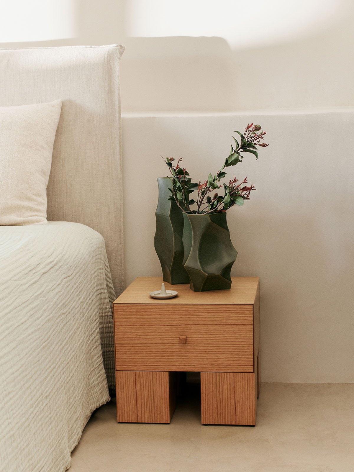 Kuben Sängbord 1x1 bredvid säng dekorerat med blommor i vas