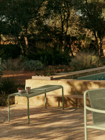 Dapple Bänk i färgen Tea Green utomhus i solnedgången