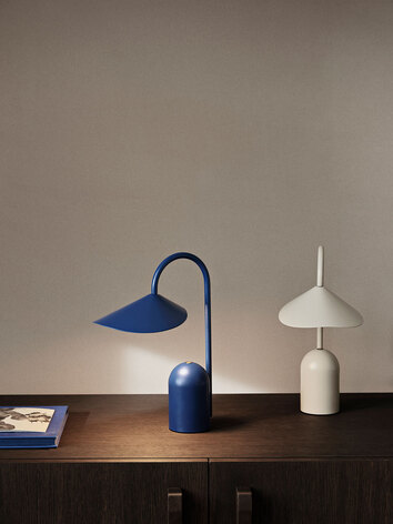 Arum Portabel Lampa i färgerna Bright Blue och Cashmere på ett sideboard