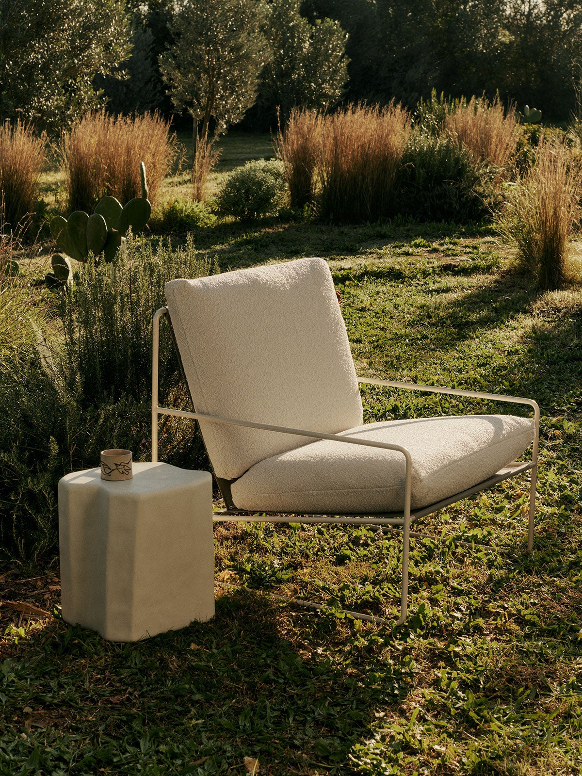 Desert Fåtölj i utförandet Cashmere/Bouclé Off-White på solig gräsmatta