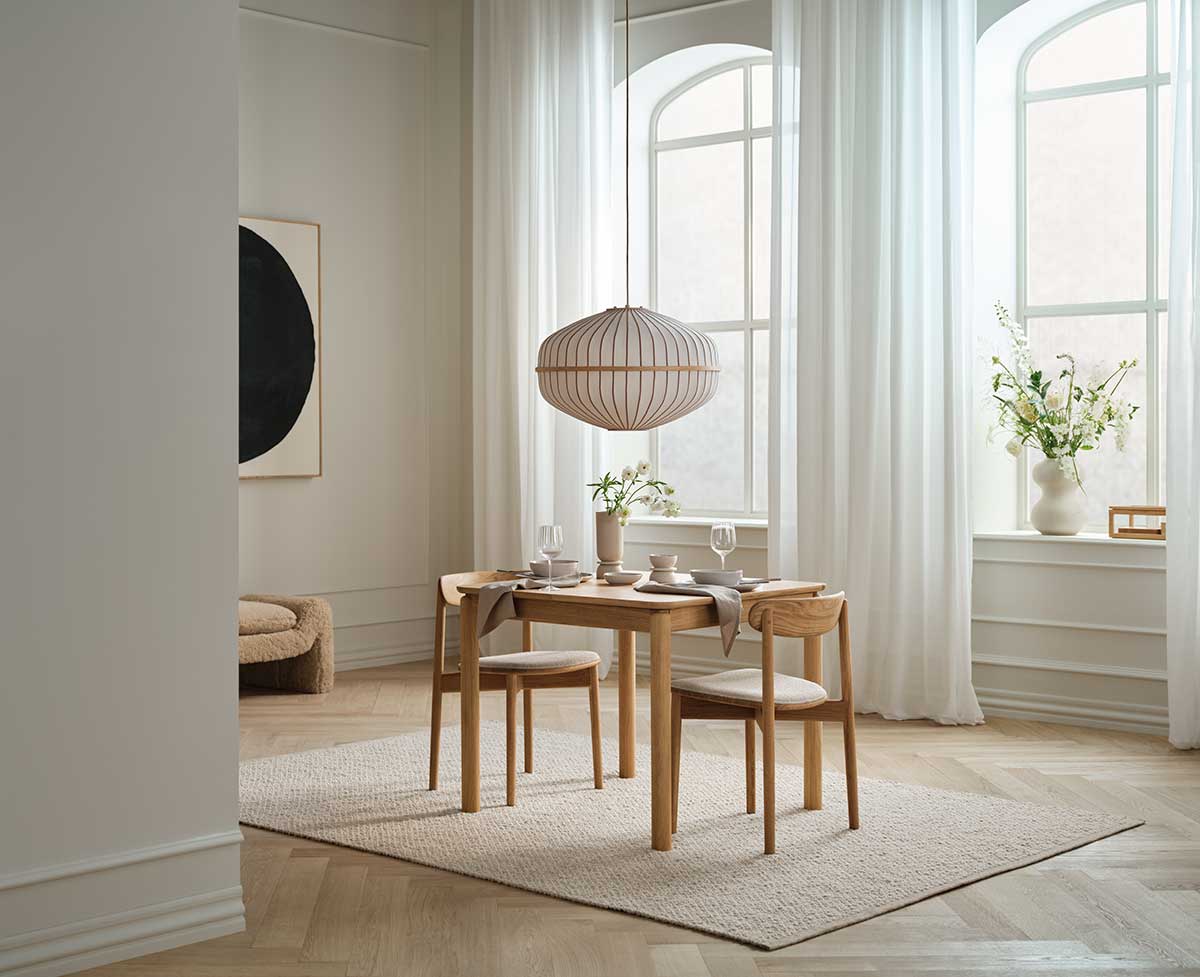 Lucen pendel diameter 60 i oljad ek hängande över en matgrupp i en ljus matsal.