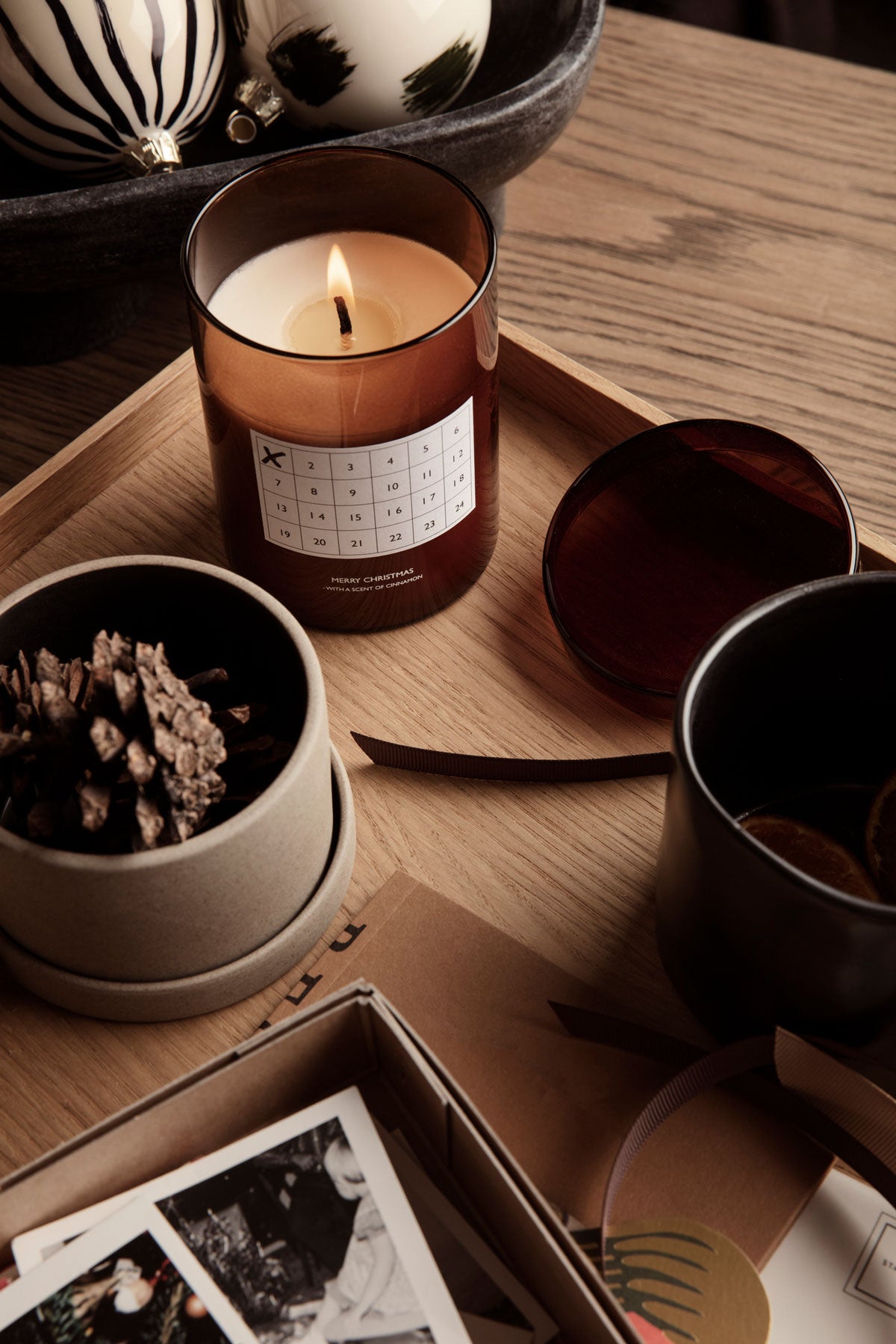 Bon Förvaringsask i liten storlek på en bricka bredvid ett brinnande ljus