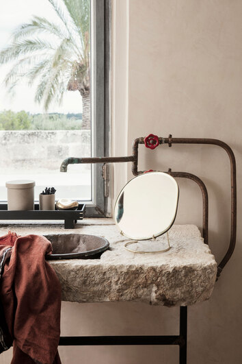 Pond Bordsspegel i utförandet Brass på kommod i badrum